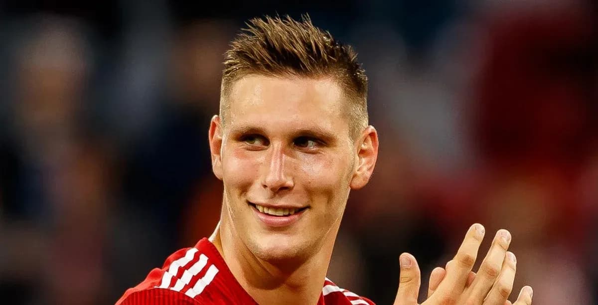 Player in red jersey smiling and applauding