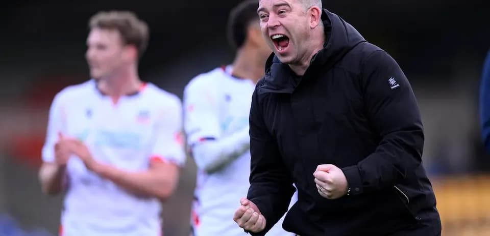 Coach celebrating victory with players in background