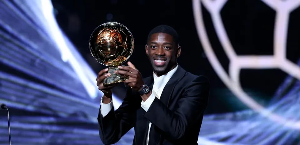 Player holding the Ballon d'Or trophy on stage