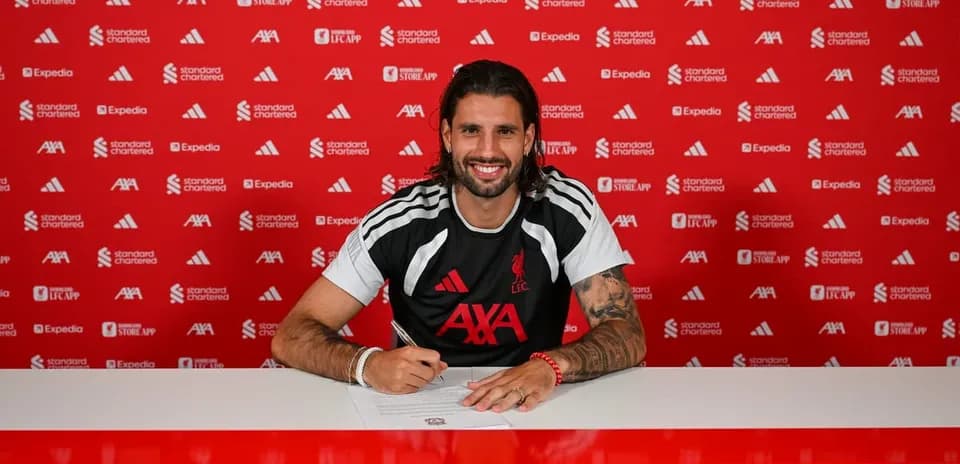 Player signing contract at press conference table