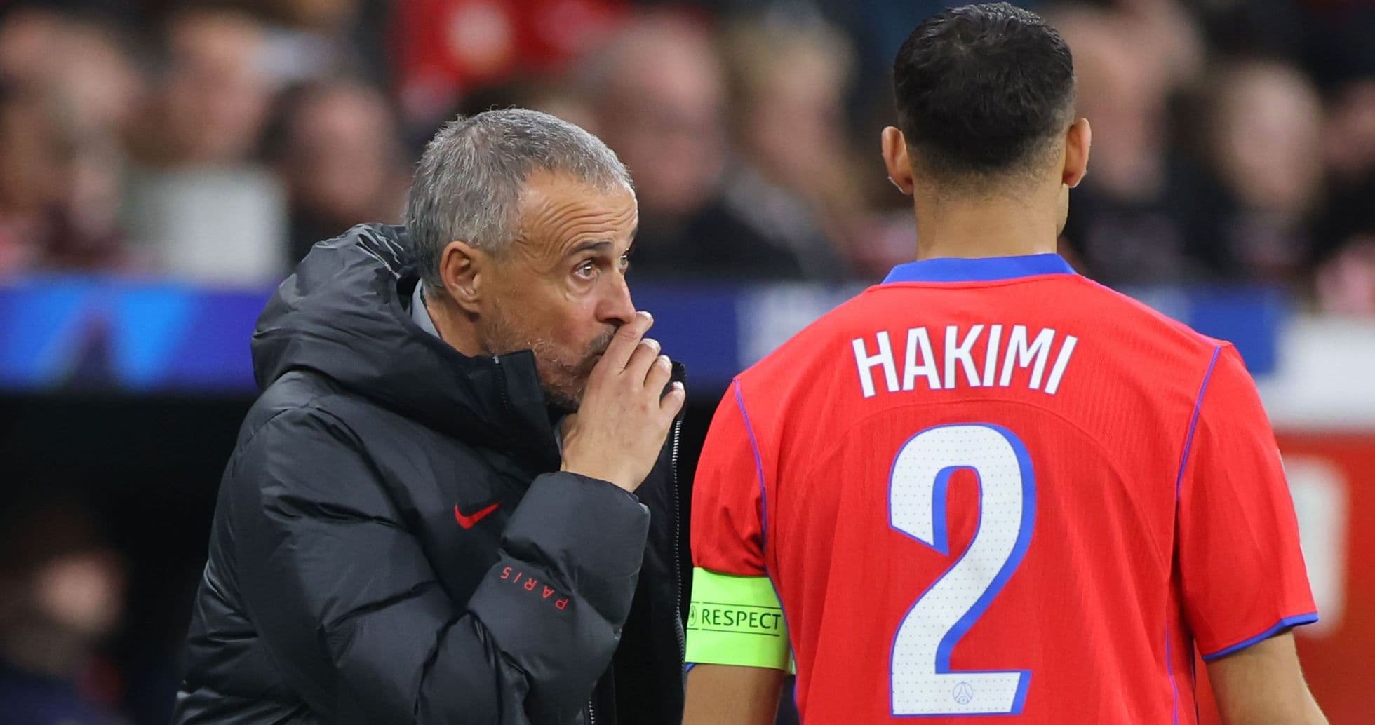 Coach discussing strategy with player Hakimi on sidelines