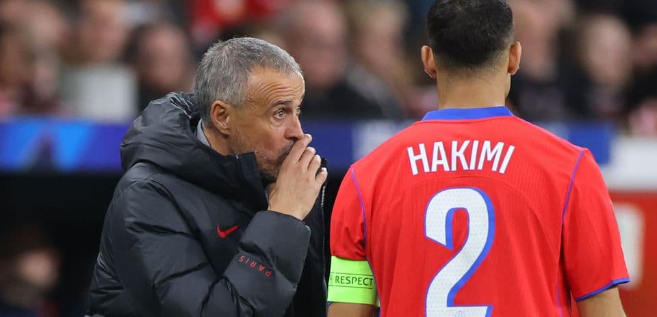 Coach discussing strategy with player Hakimi on sidelines