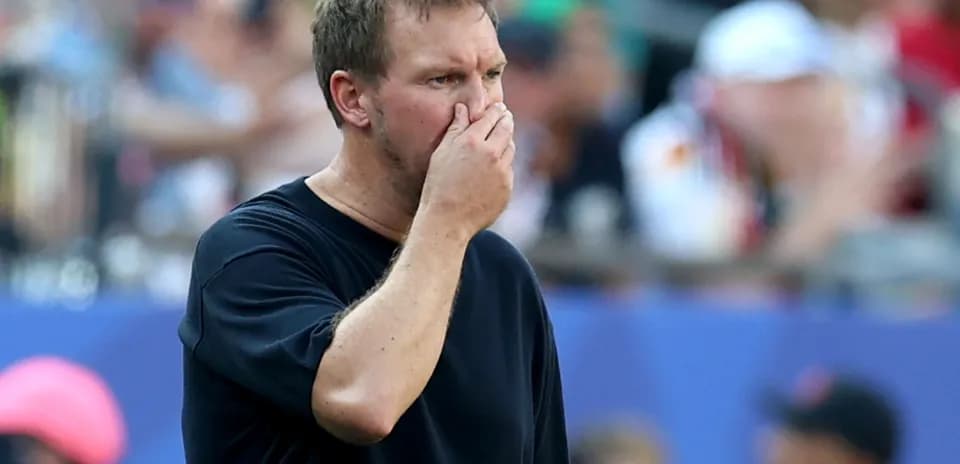 Coach observing the match with a concerned expression