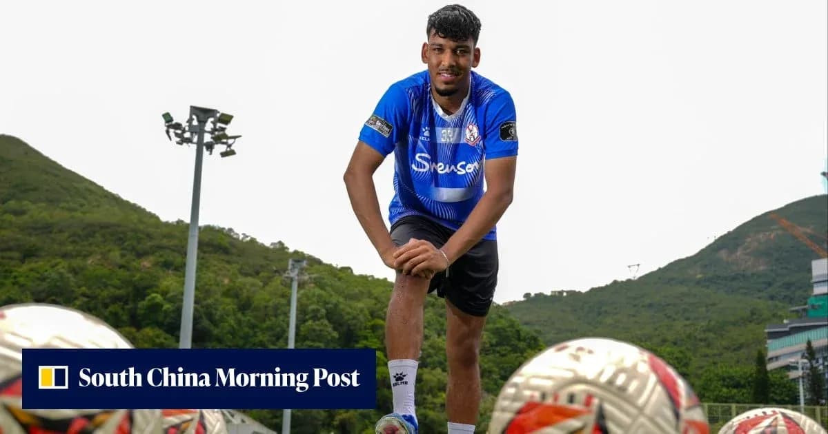 Player posing on training ground with footballs