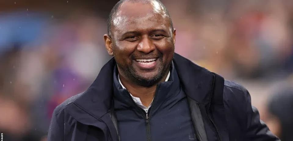 Coach smiling during a match on the sidelines