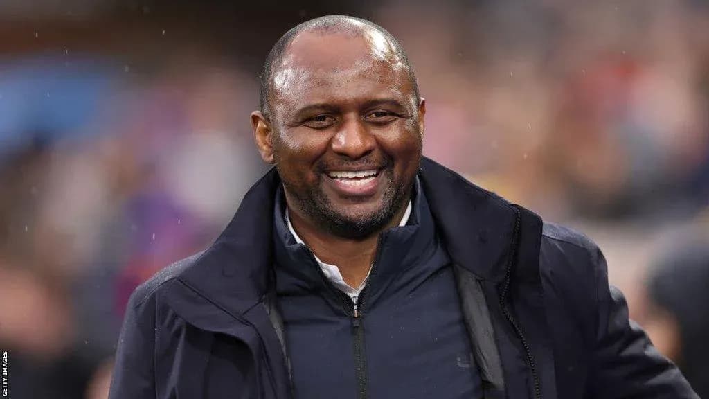 Coach smiling during a match on the sidelines