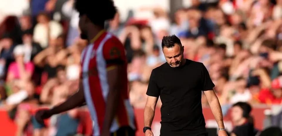 Manager walking past player during match at stadium