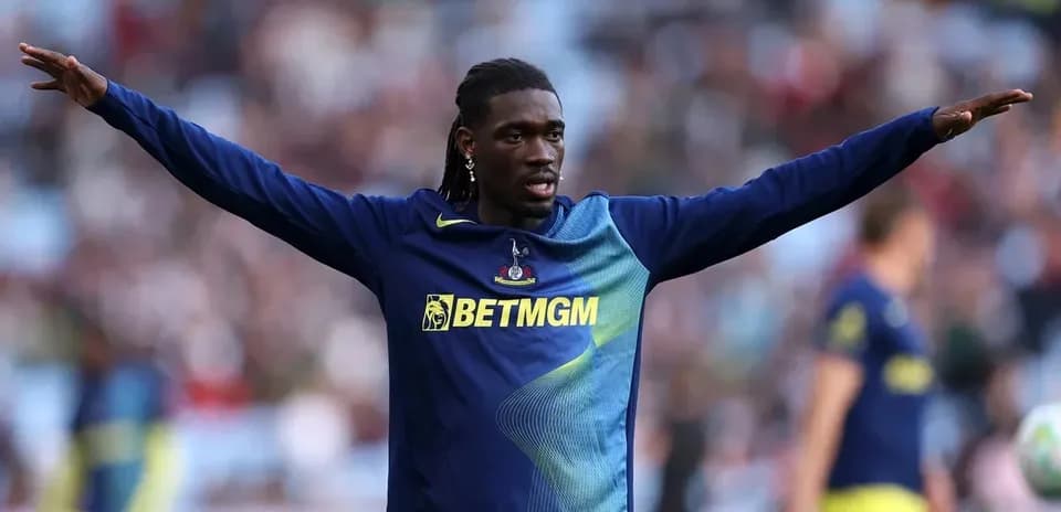 Player warming up with arms outstretched on field