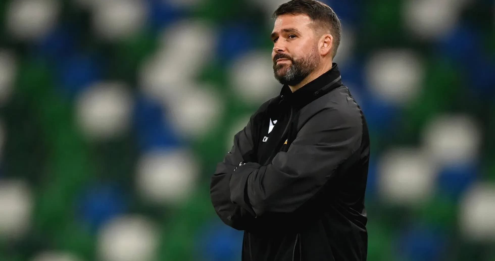 Coach observing match with arms crossed