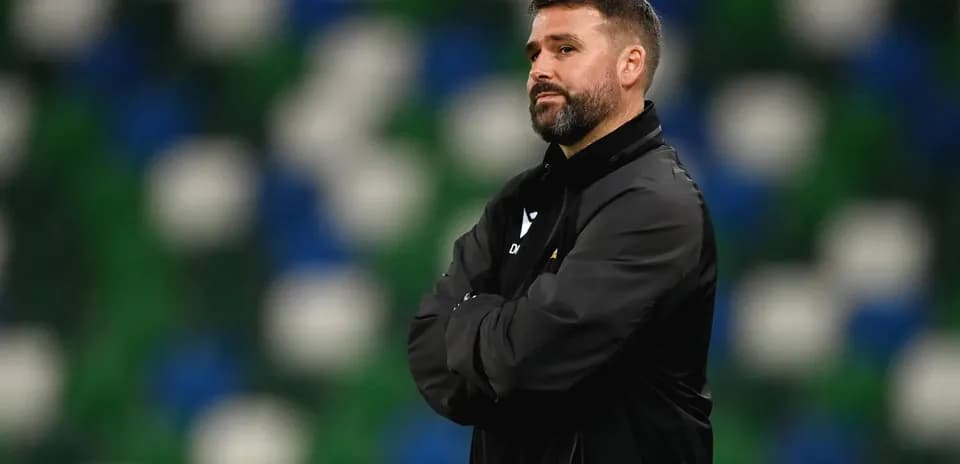 Coach observing match with arms crossed