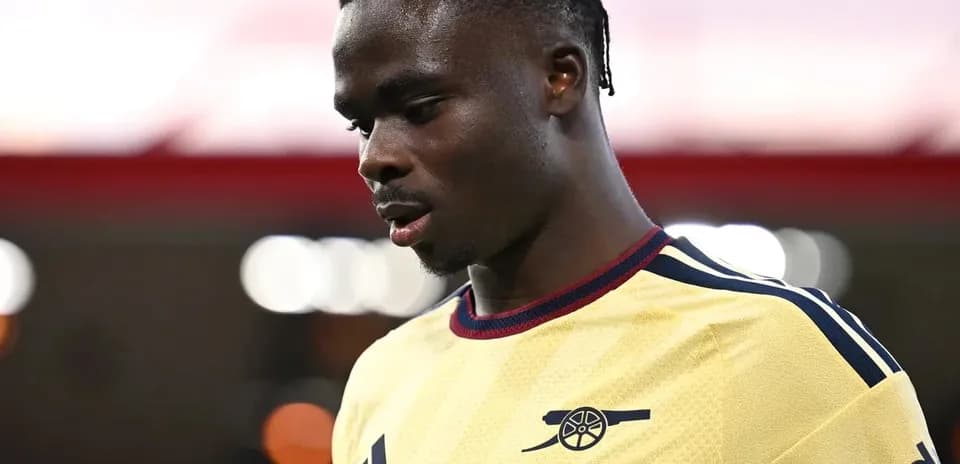 Player wearing Arsenal jersey looking down