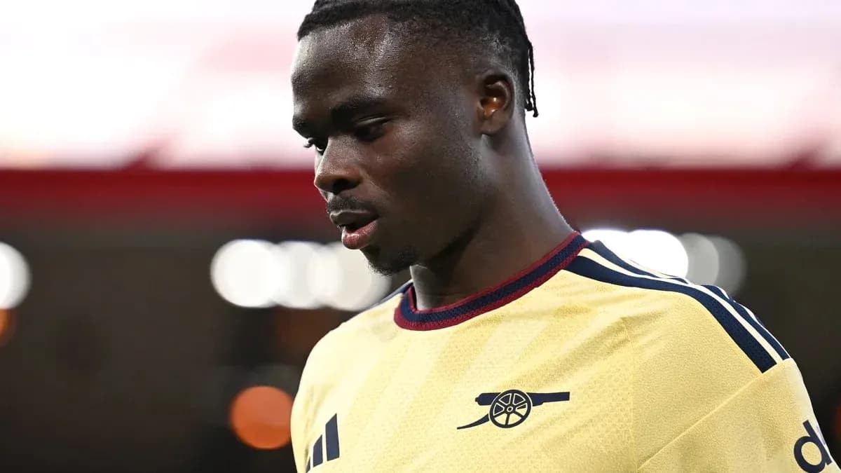 Player wearing Arsenal jersey looking down