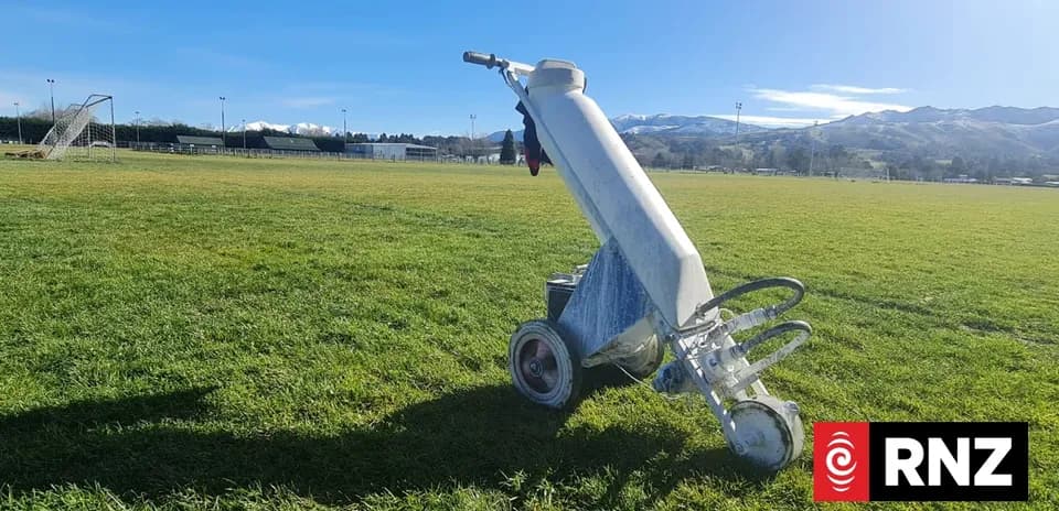 Line marking machine on grassy sports field