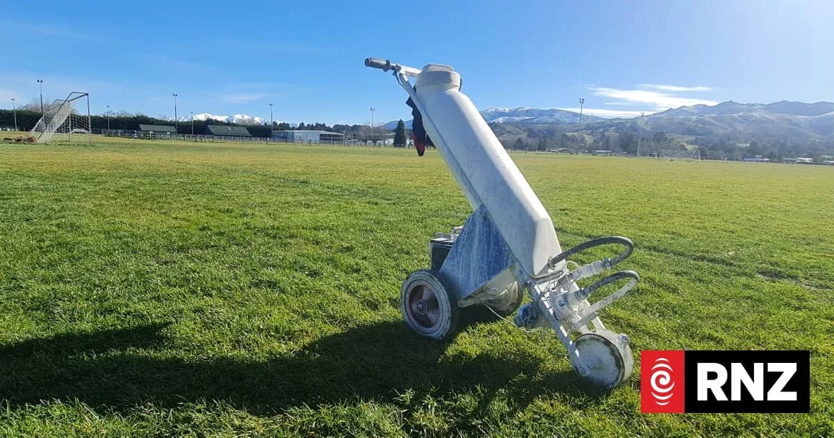 Line marking machine on grassy sports field