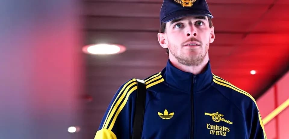 Player walking in team tracksuit with bag