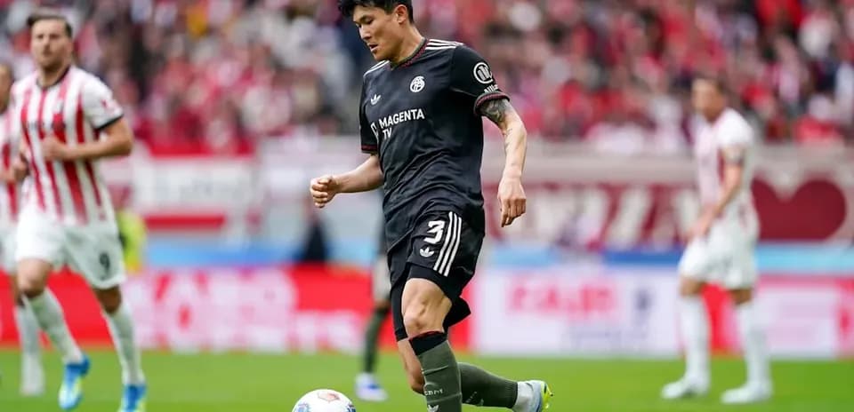 Player in black kit preparing to kick ball during match