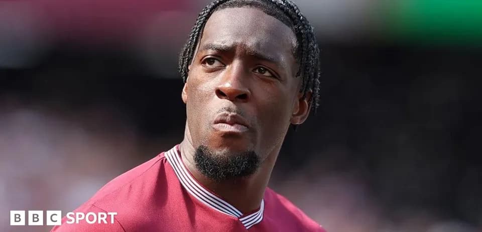 Player in maroon kit during match warm-up