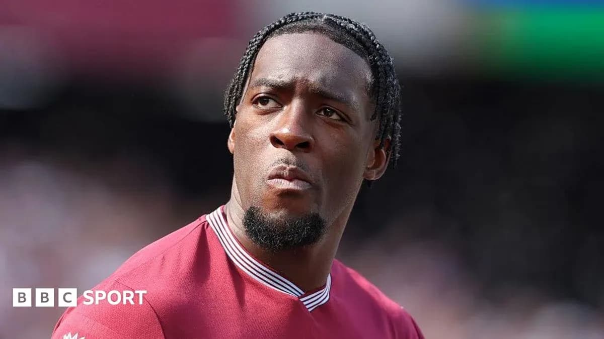 Player in maroon kit during match warm-up