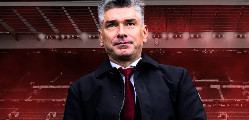 Man in black jacket at stadium backdrop