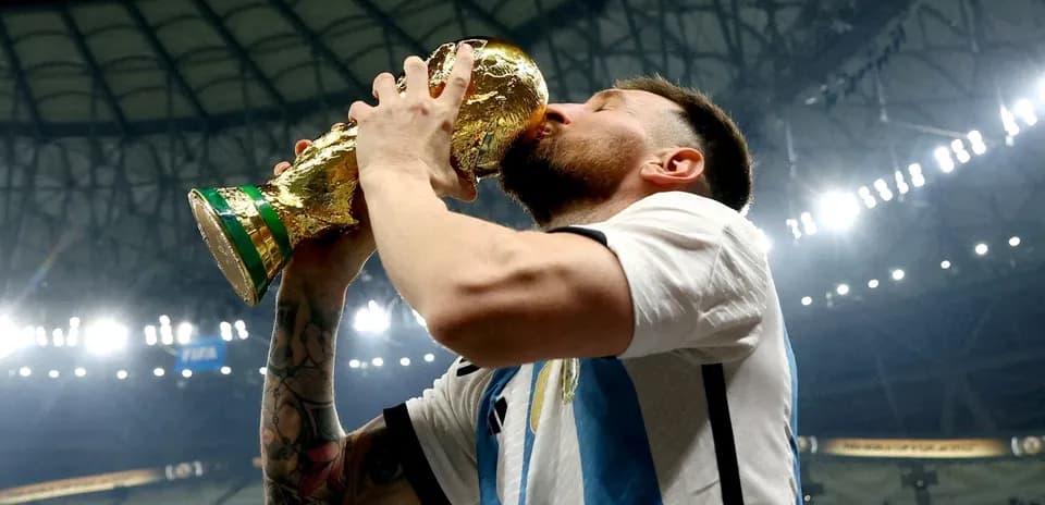 Player kissing FIFA World Cup trophy in stadium