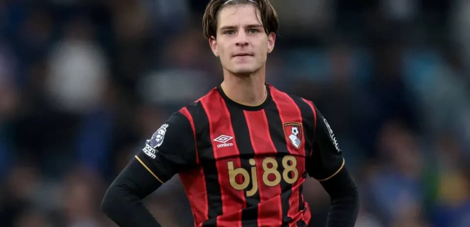 Bournemouth player in red and black jersey on pitch