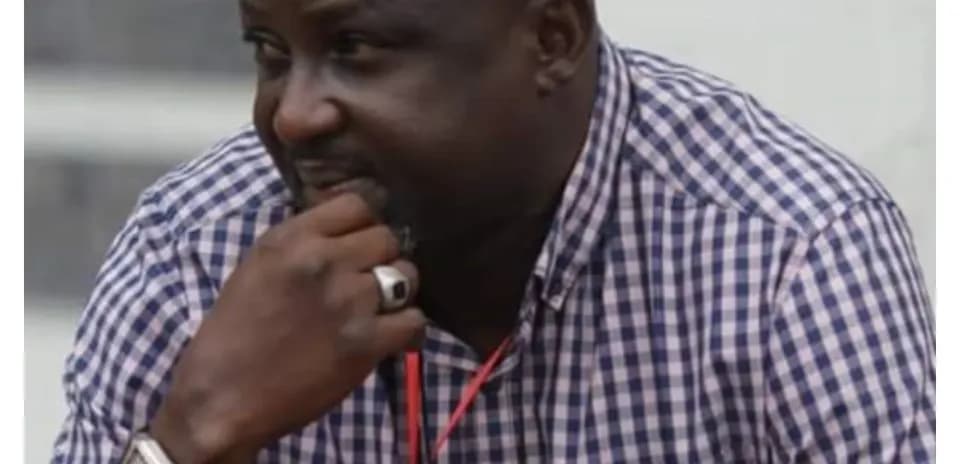 Man in checkered shirt pondering during event
