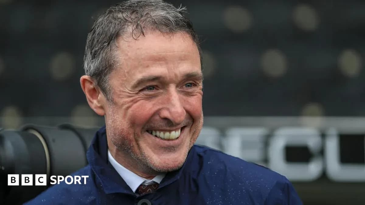 Man smiling in a raincoat at stadium