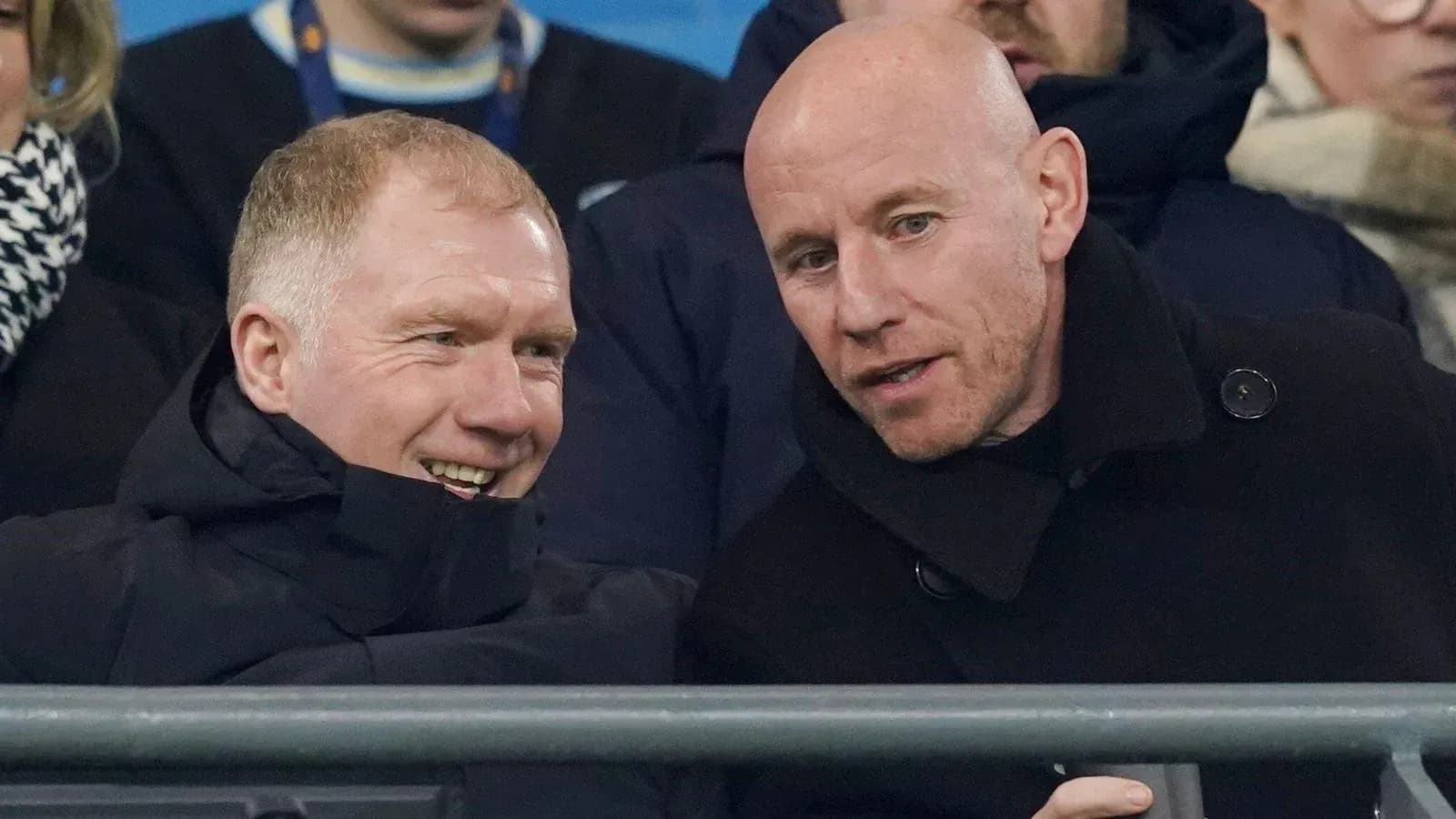 Two men conversing in stadium seating area