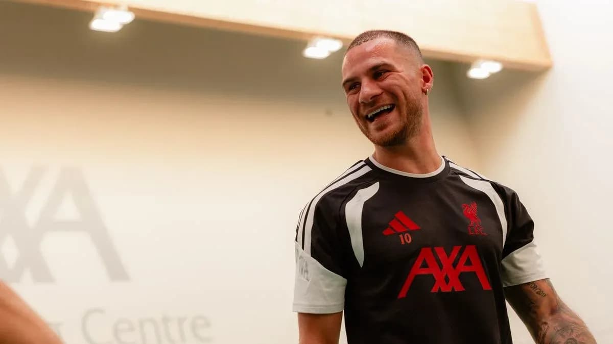 Player smiling in Liverpool training kit at AXA Centre
