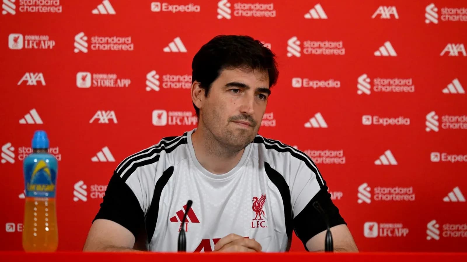 Manager seated at press conference table with branding