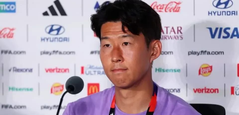 Player at press conference with sponsors' logos behind