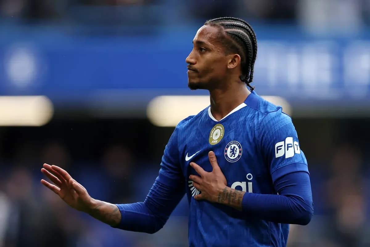 Player in blue Chelsea jersey gesturing to fans