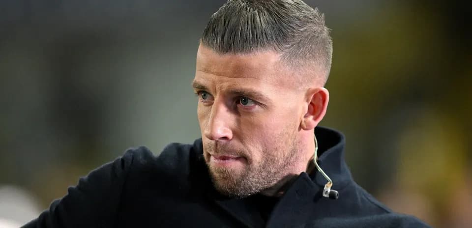 Man with short hair wearing a dark coat