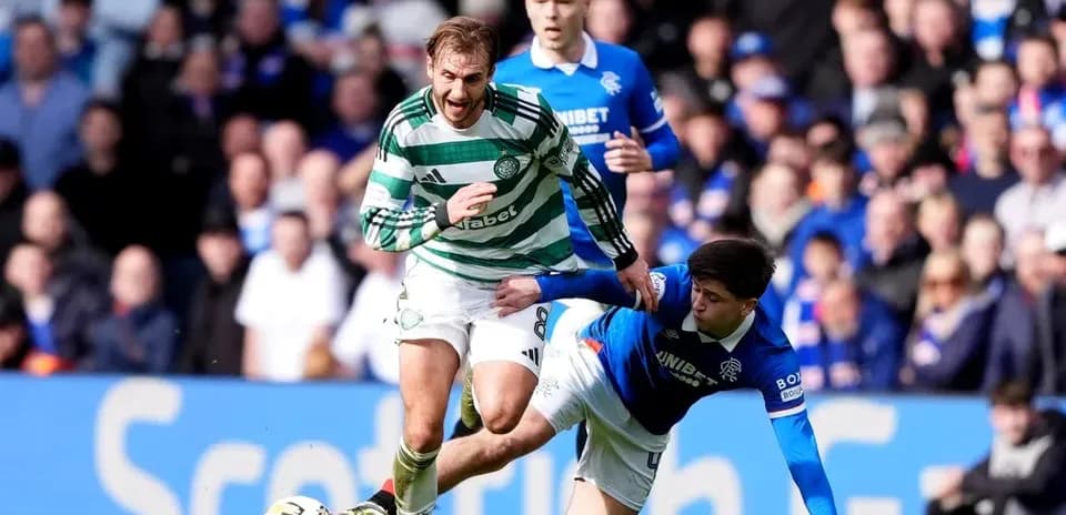 Celtic player evading a tackle from Rangers opponent