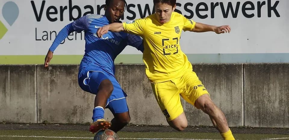 Two players competing for the ball in football match