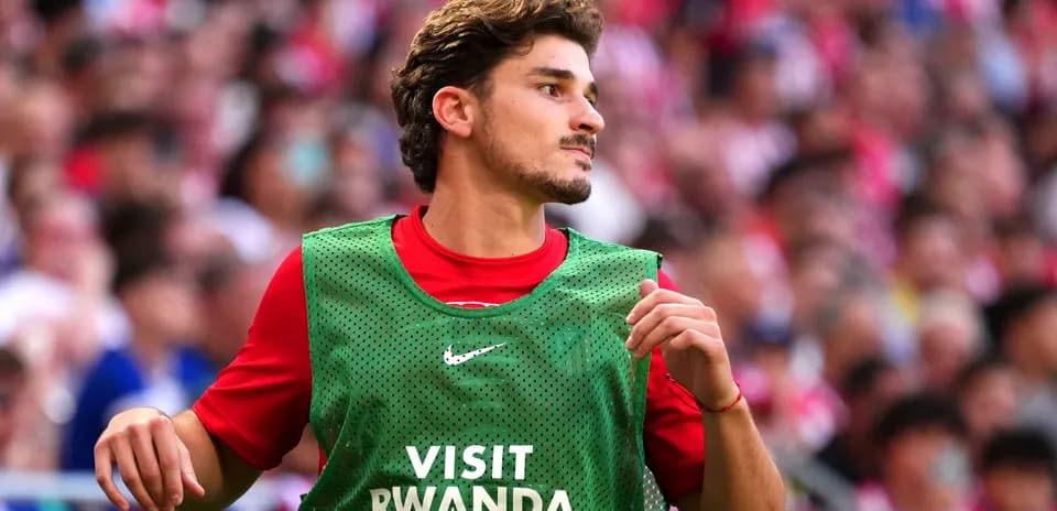 Player warming up in green training bib on pitch