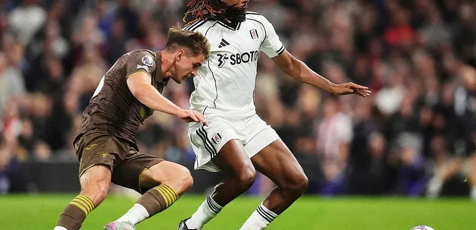 Brentford player challenging Fulham player for ball