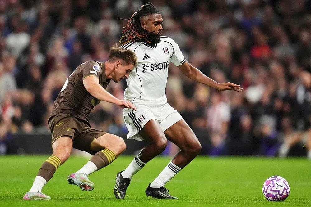 Brentford player challenging Fulham player for ball