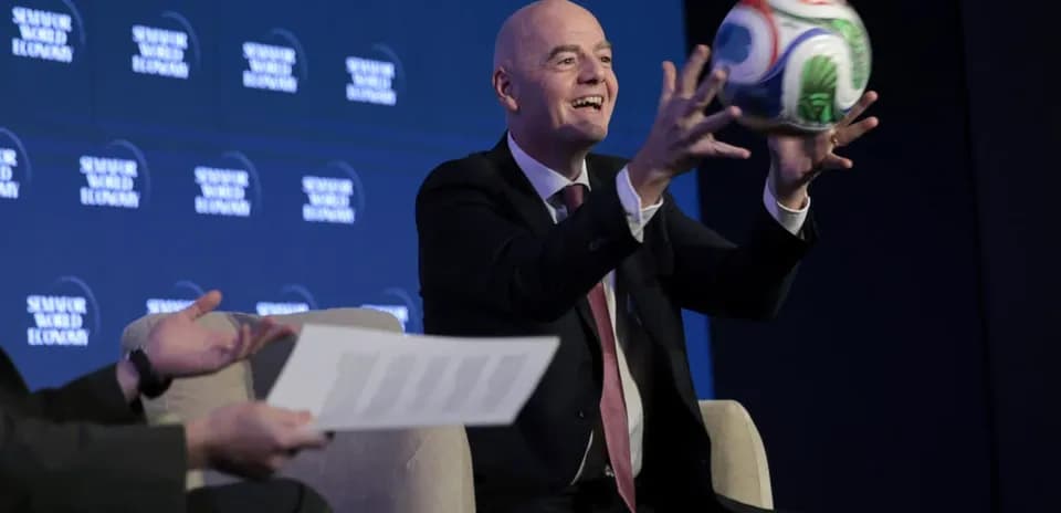 Official holding a soccer ball at conference