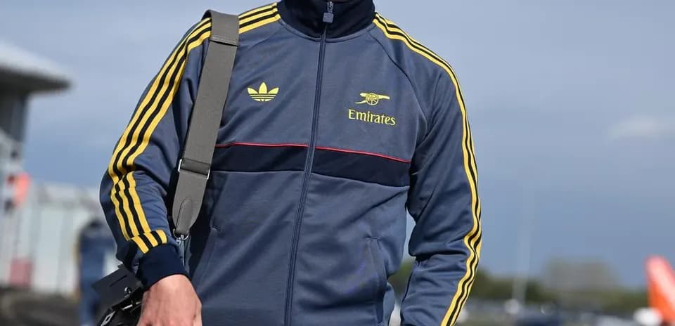 Athlete wearing tracksuit and cap at airport