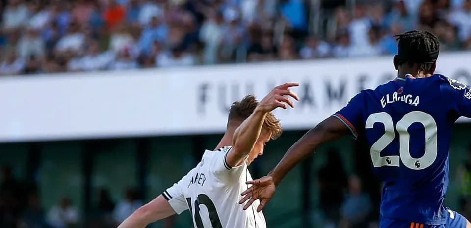 Fulham player challenging Newcastle opponent for the ball