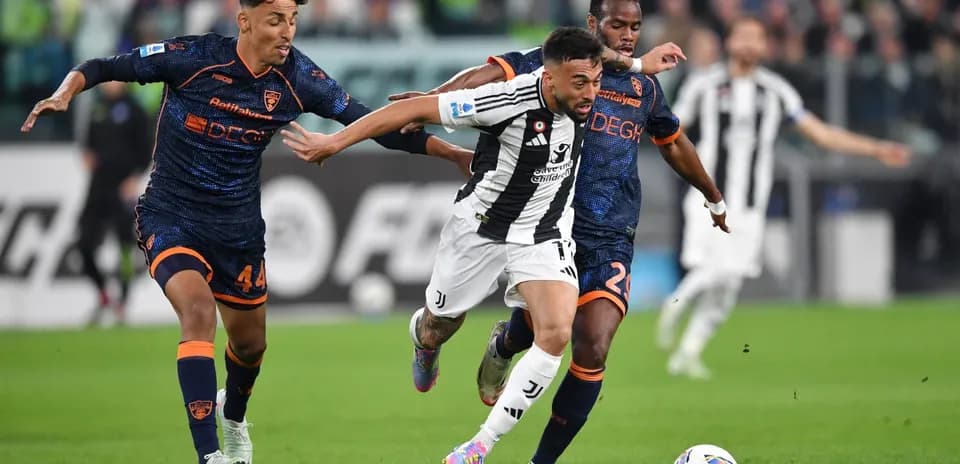 Juventus player dribbling past Lecce defenders