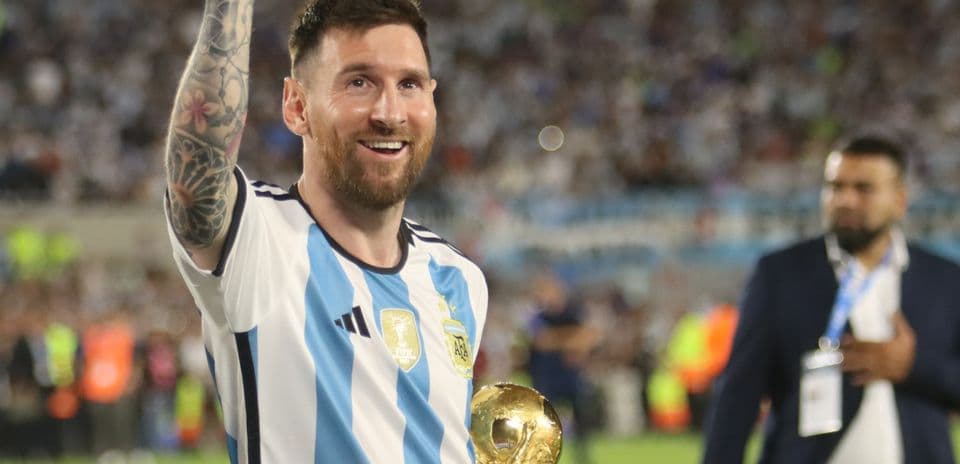 Player celebrating with World Cup trophy in stadium