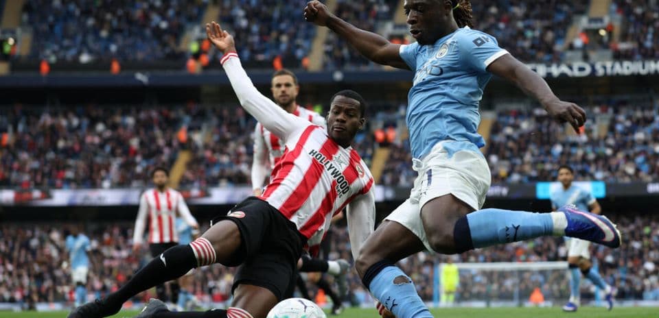 Player tackling opponent during match at Etihad Stadium