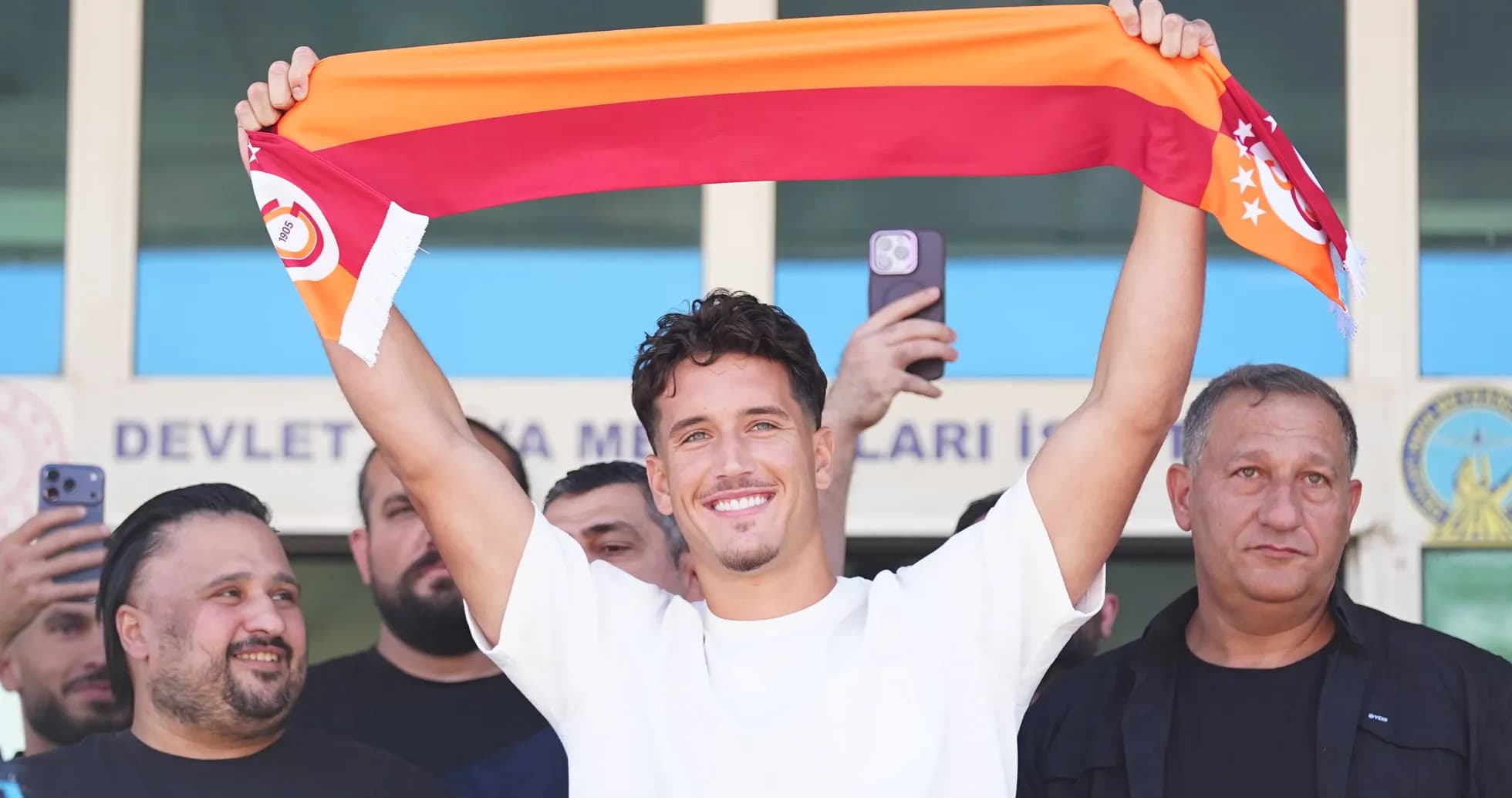 Player holding Galatasaray scarf at announcement event