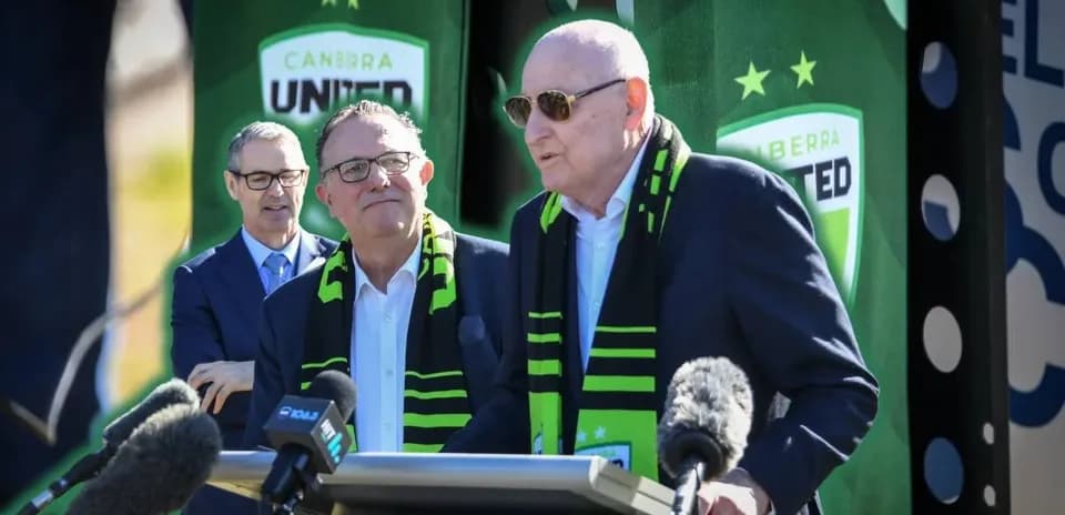 Officials speaking at Canberra United event with scarves