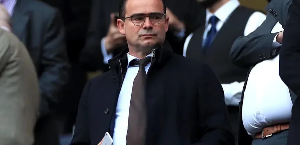Man in a suit observing from the stands
