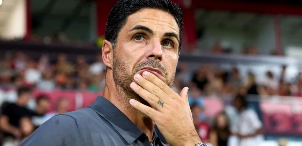 Coach pondering during a match with spectators in background
