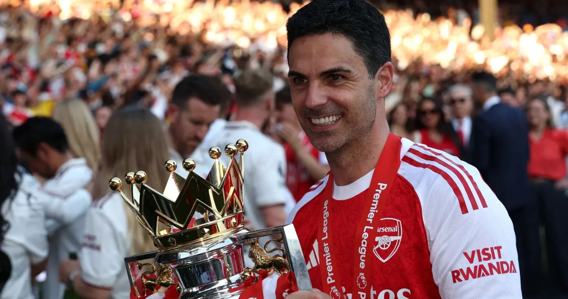 Arsenal manager holding Premier League trophy at celebration