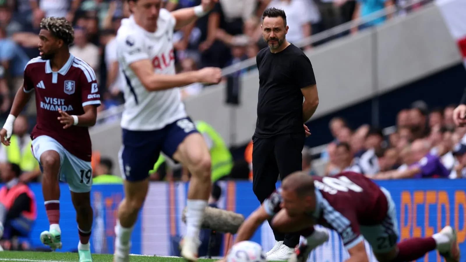Aston Villa player dribbling past Tottenham defenders